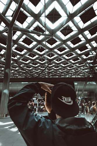 netherlands man wearing black Nike flat brimmed cap holding camera urban